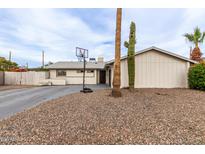 Charming single-story home with a desert landscaped yard and a basketball hoop at 2001 W Surrey Ave, Phoenix, AZ 85029