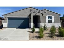 Charming single-story home featuring a blue garage door and low-maintenance desert landscaping at 22490 W Tonopah Dr, Surprise, AZ 85387