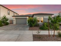 Charming home featuring a gray stucco exterior, a gray garage door, and lovely curb appeal at 22609 E Roundup Way, Queen Creek, AZ 85142