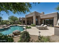 Inviting backyard pool and patio area perfect for relaxing and entertaining with desert landscape at 34221 N Boulders Pkwy, Scottsdale, AZ 85266