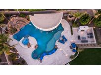 Aerial view of a custom pool with grotto, swim-up bar, water slide, and poolside fireplace and seating at 4281 S Iowa St, Chandler, AZ 85248
