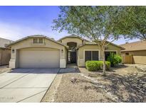 Charming single-story home featuring a manicured front yard with desert landscaping and a two-car garage at 43283 W Hillman Dr, Maricopa, AZ 85138