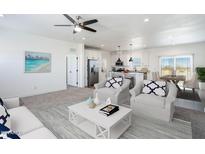 Bright, open-concept living room features modern ceiling fan, updated decor, and flows seamlessly into the kitchen at 51942 W Sotol Rd, Maricopa, AZ 85139