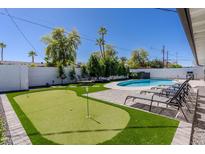 Beautiful backyard featuring a putting green, swimming pool, lounge chairs, and nice landscaping at 6413 E Parkview Dr, Scottsdale, AZ 85257