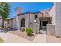 Charming townhouse with desert landscaping, an arched window, and a private gated front entry at 1718 S Longmore -- # 95, Mesa, AZ 85202