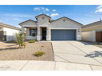 Charming single-story home featuring a gray garage door and low maintenance desert landscaping at 17836 W Mission Ln, Waddell, AZ 85355