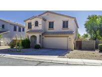 Beige two-story home featuring a two-car garage, tile roof and desert landscaping in front at 20200 N Donithan Way, Maricopa, AZ 85138