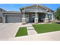 Charming single-story home with a gray exterior, stone accents, and a well-manicured lawn at 22728 E Camacho Rd, Queen Creek, AZ 85142