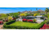 Stunning exterior view of a modern home, showcasing lush landscaping, a pool, and mountain views at 4218 E Palo Verde Dr, Phoenix, AZ 85018
