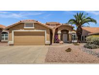 Charming home with a tan exterior, desert landscaping, and a two-car garage at 4434 E Thistle Landing Dr, Phoenix, AZ 85044