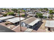 A charming manufactured home features a spacious carport and low maintenance desert landscaping at 500 N 67Th Ave # 52, Phoenix, AZ 85043