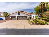Charming home featuring a three car garage, beautiful landscaping, and desert plants in the front yard at 6154 E Karen Dr, Scottsdale, AZ 85254