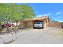 Cozy single-story home with a covered parking area and mature trees in a residential neighborhood at 7038 W Fillmore St, Phoenix, AZ 85043