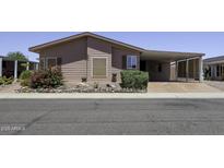 Charming single-story home with a covered carport and desert landscaping featuring a colorful flowering bush at 880 W Moon Shadow Dr, Casa Grande, AZ 85122