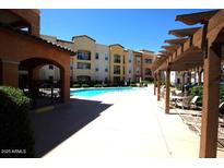 Beautiful community pool and pergola in a multi-Gathering home complex with seating areas at 14575 W Mountain View Blvd # 11212, Surprise, AZ 85374