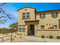 Charming two-story home featuring a stucco facade, arched entryway, and desert landscaping at 14870 W Encanto Blvd # 1106, Goodyear, AZ 85395