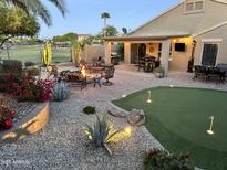 Beautiful backyard patio with outdoor seating, fire pit, mini golf course, grill and desert landscaping at 2 W Pasture Canyon Dr, San Tan Valley, AZ 85143