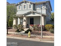 Charming two-story home featuring stone accents, covered porch, landscaped yard, and neutral gray siding at 21134 W Green St, Buckeye, AZ 85396