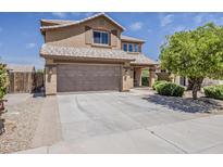 Charming two-story home with a desert landscape, a tile roof and a spacious driveway leading to the garage at 2408 W Saint Kateri Dr, Phoenix, AZ 85041