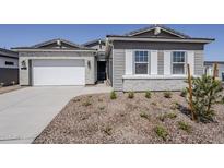 Charming home showcasing a brick and siding exterior with a well-manicured front yard at 35524 N Tin Ct, San Tan Valley, AZ 85144