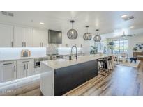 Bright kitchen features a large island with bar seating, modern appliances, and stylish pendant lighting at 36601 N Mule Train Rd # D1, Carefree, AZ 85377