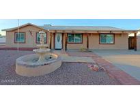 Charming home featuring a well-maintained front yard with a decorative water fountain and stone accents at 4132 E Sweetwater Ave, Phoenix, AZ 85032