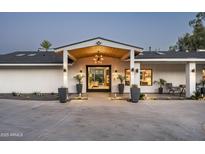 Elegant home exterior featuring a grand entrance with manicured landscaping and stylish lighting at 7100 N 47Th St, Paradise Valley, AZ 85253