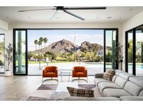 Bright, airy living room with floor-to-ceiling windows offering stunning views of the pool and surrounding landscape at 7100 N 47Th St, Paradise Valley, AZ 85253