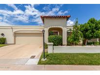 Charming single-story home with a beige stucco exterior, terra cotta tile accents, and a well-manicured front lawn at 7354 E San Miguel Ave, Scottsdale, AZ 85250