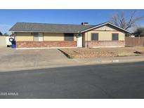 Charming single-story home featuring a well-maintained yard, driveway, and classic brick accents at 742 S Los Alamos --, Mesa, AZ 85204