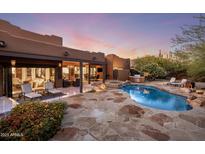 Inviting backyard pool and patio area with lush landscaping, comfortable seating, and a built-in outdoor kitchen at 7547 E Mary Sharon Dr, Scottsdale, AZ 85266