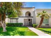 Charming two-story condo featuring a gated entry, balcony, and lush desert landscaping at 7684 E Minnezona Ave, Scottsdale, AZ 85251