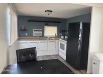 Eat-in kitchen area with modern laminate flooring and white cabinetry at 9913 E Main St # 40, Mesa, AZ 85207