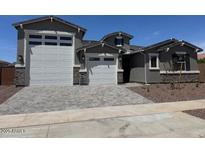 Charming home featuring a 3-car garage and inviting curb appeal with landscaped yard and stone accents at 23796 N 165Th Dr, Surprise, AZ 85387