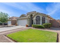 Inviting single-story home with a well-manicured lawn, landscaping, and a two-car garage at 3418 W Maldonado Rd, Phoenix, AZ 85041