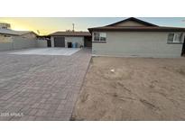 A single-story home boasts desert landscaping, a brick driveway, and an attached garage at 5338 W Wolf St, Phoenix, AZ 85031
