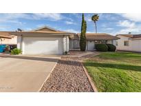 Charming single-story home featuring a well-manicured front yard, desert landscaping, and a two-car garage at 6873 E Kathleen Rd, Scottsdale, AZ 85254