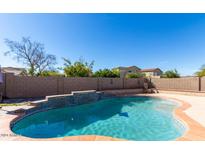 Refreshing pool with decorative water feature, surrounded by a brick wall, offers a private outdoor oasis at 7117 W Globe Ave, Phoenix, AZ 85043