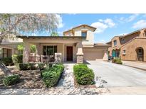 Charming two-story home featuring a covered porch, stone accents, and a well-manicured front yard at 13256 N 153Rd Ln, Surprise, AZ 85379