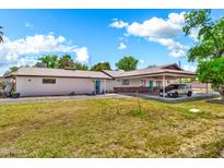 Charming single story home with carport and manicured front lawn under a bright blue sky at 1451 E Brown Rd, Mesa, AZ 85203
