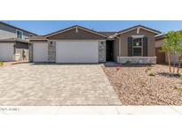 Charming single-story home featuring a three-car garage, stone accents, and a beautifully landscaped front yard at 18189 W Hess St, Goodyear, AZ 85338