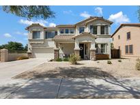Charming two-story stucco home featuring a well-manicured yard and attached two-car garage at 19820 E Reins Rd, Queen Creek, AZ 85142