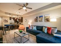 Inviting living room with sectional sofa, modern ceiling fan, and view into the kitchen at 5450 E Deer Valley Dr # 1176, Phoenix, AZ 85054