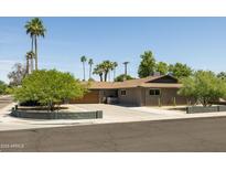 Charming single-story home with desert landscaping, mature trees, and a spacious driveway at 8502 E Rose Ln, Scottsdale, AZ 85250
