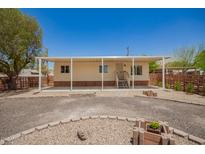 Charming single-story home featuring a covered porch, desert landscaping, and a gravel driveway under a clear blue sky at 9710 E Baywood Ave, Mesa, AZ 85208