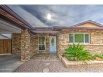 Charming home with stone facade, well-maintained landscaping, and covered entrance at 9710 N 55Th Ave, Glendale, AZ 85302