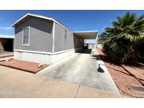 Charming mobile home featuring desert landscaping, a covered carport and a cozy front yard at 1002 W Kachina Trl, Phoenix, AZ 85041