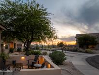 Inviting outdoor patio with desert landscaping, seating, and a beautiful sunset view at 10527 E Acacia Dr, Scottsdale, AZ 85255