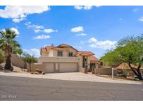 Beautiful two-story home featuring a three-car garage, tile roof, and well-manicured desert landscaping at 1221 E Claire Dr, Phoenix, AZ 85022