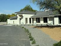 Inviting single-story home with stone driveway, desert landscaping, and neutral paint scheme at 13365 N 74Th St, Scottsdale, AZ 85260